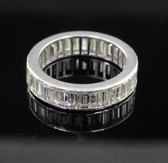 A mid 20th century platinum? and baguette cut diamond full eternity ring, size M/N.